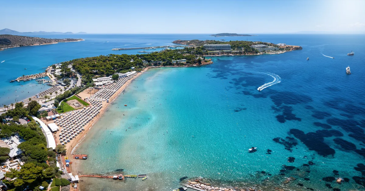 Sheltered cove with rows of sunbeds at Astir Beach, Vouliagmeni