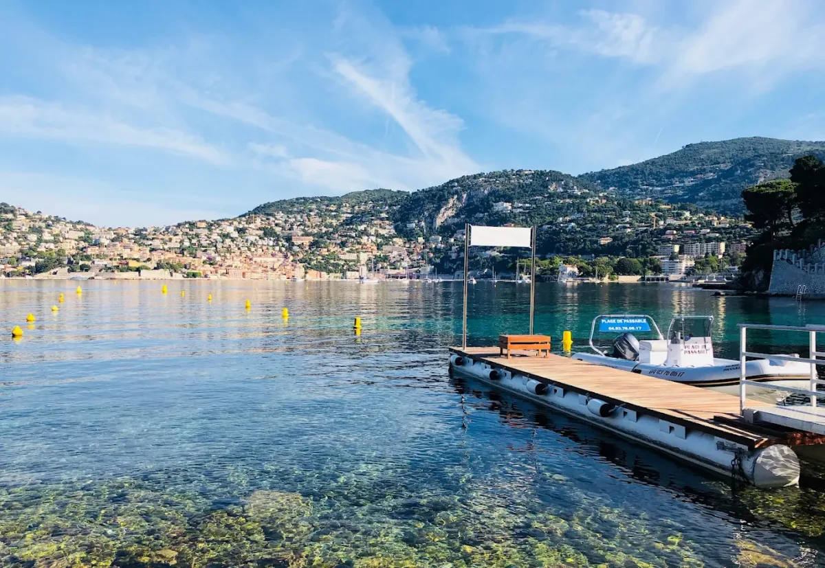 Fine-pebble cove and sun loungers at Plage de Passable, facing Villefranche bay