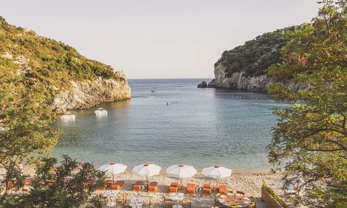 Design-led loungers over turquoise water at Aragosta Beach Club, Paleokastritsa