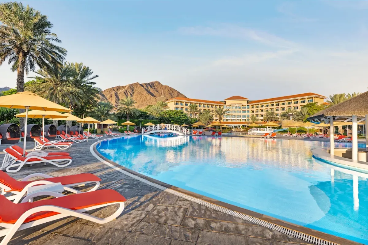 Private beach and pools backed by the Hajar Mountains at Fujairah Rotana Resort & Spa, Al Aqah
