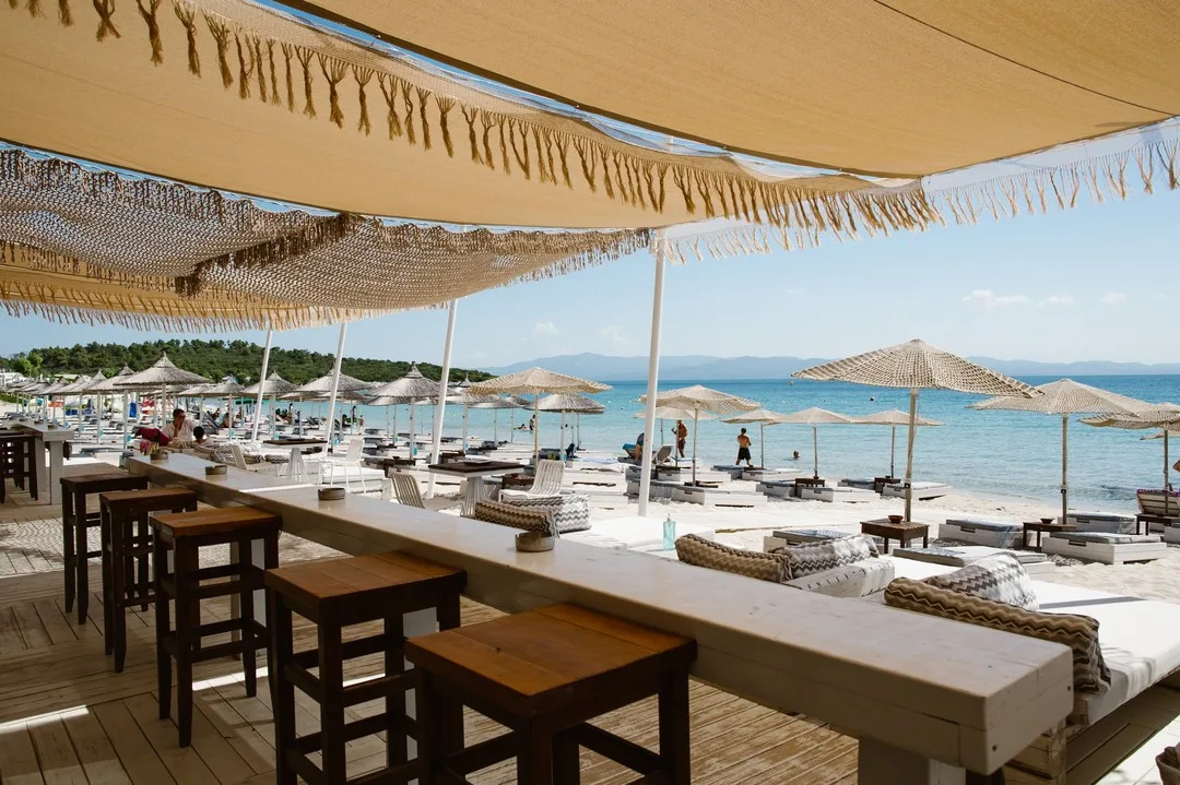 Lively sandy beach and DJ setup at Leuki Ammos Beach Bar, Kassandra