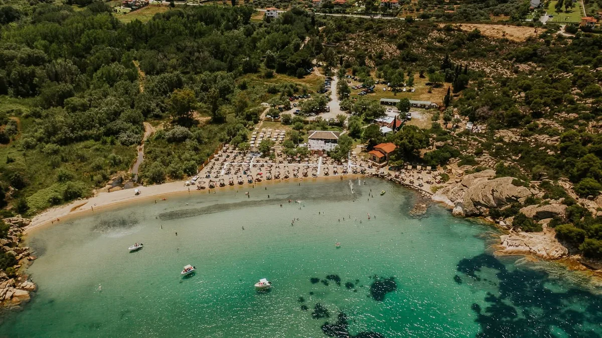 Scenic bay and beach loungers under the trees at Talgo Beach Bar, Vourvourou