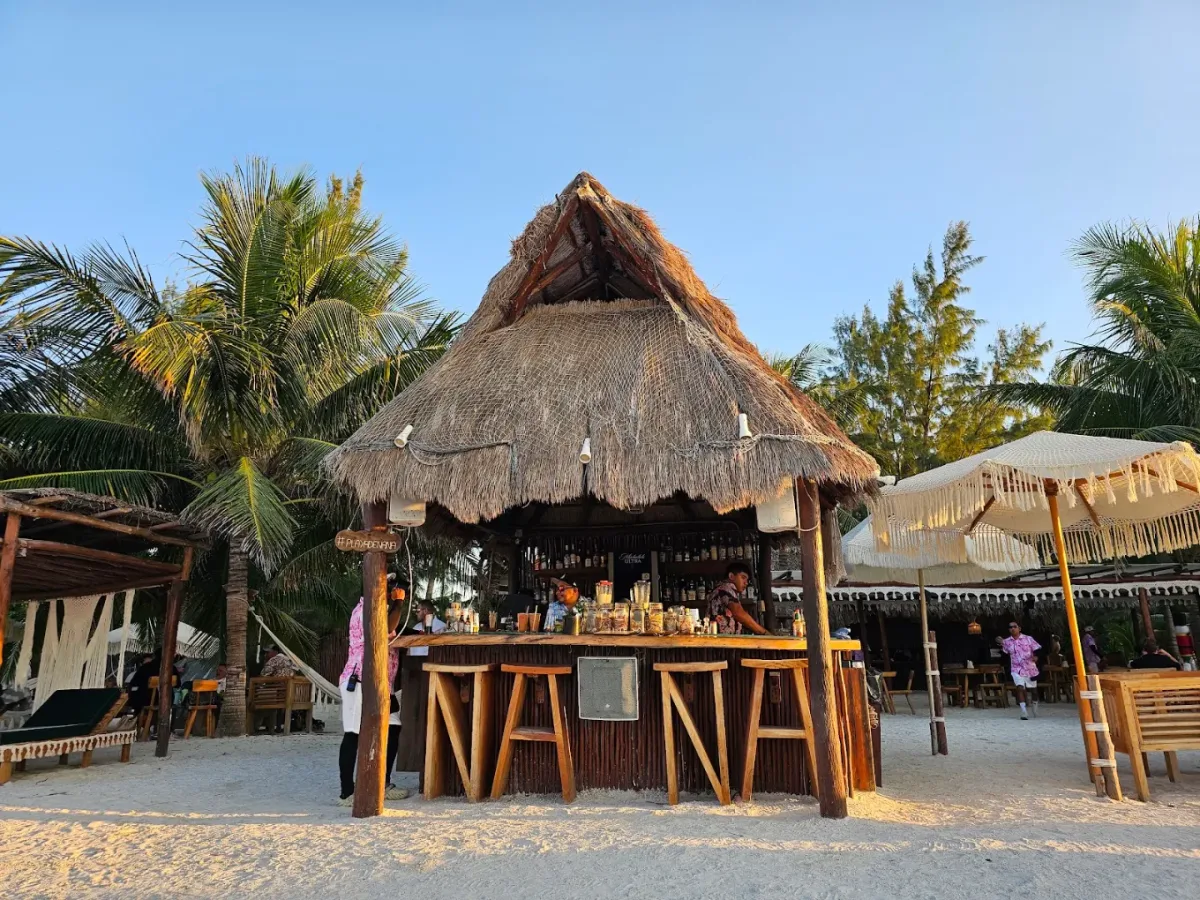 Boho beach club with macrame details and palapa shades at La Playa de Ñaña, Playa Holbox