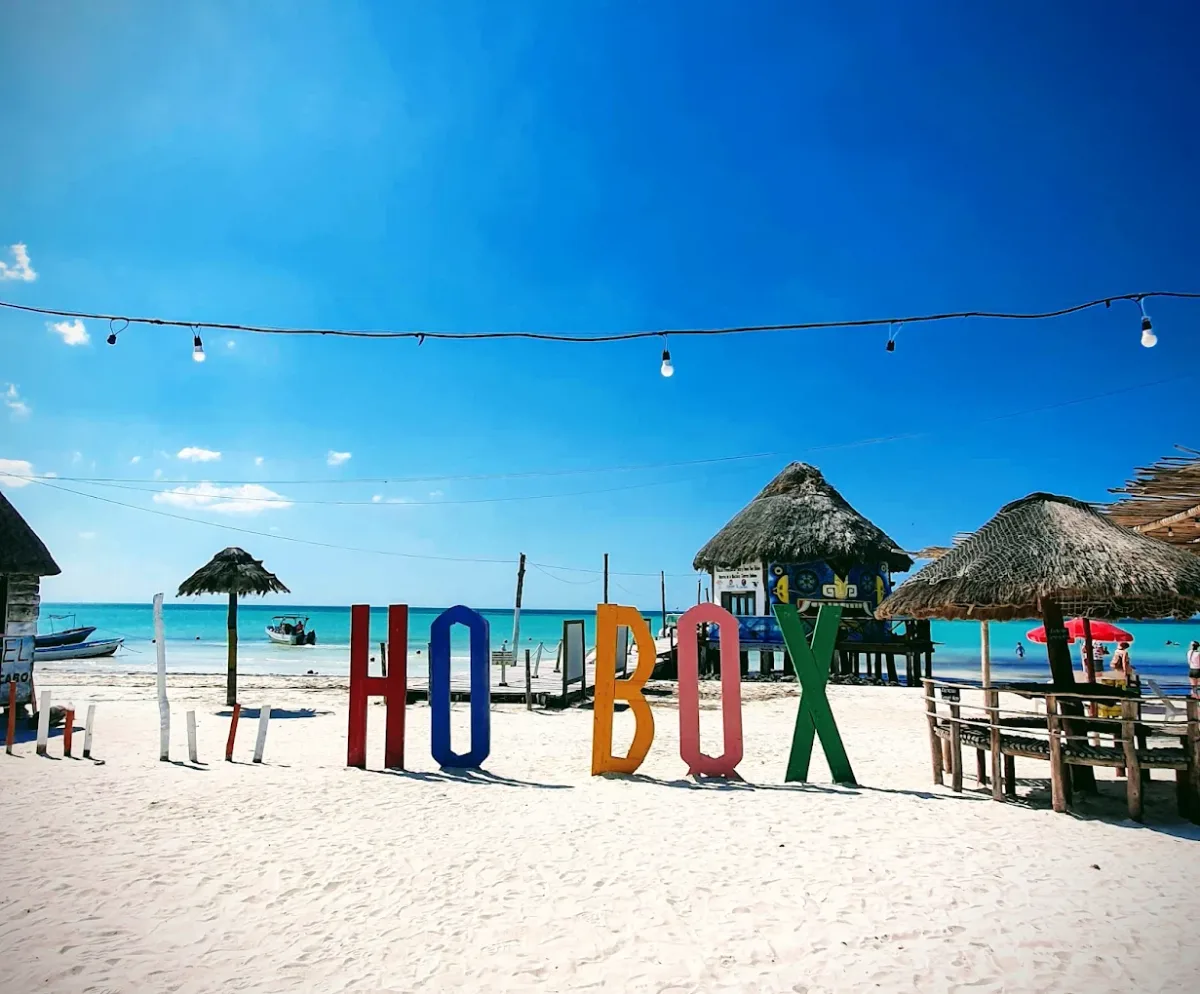 Turquoise swing seat and loungers on the sand at Capitán Capitán, next to the Holbox pier
