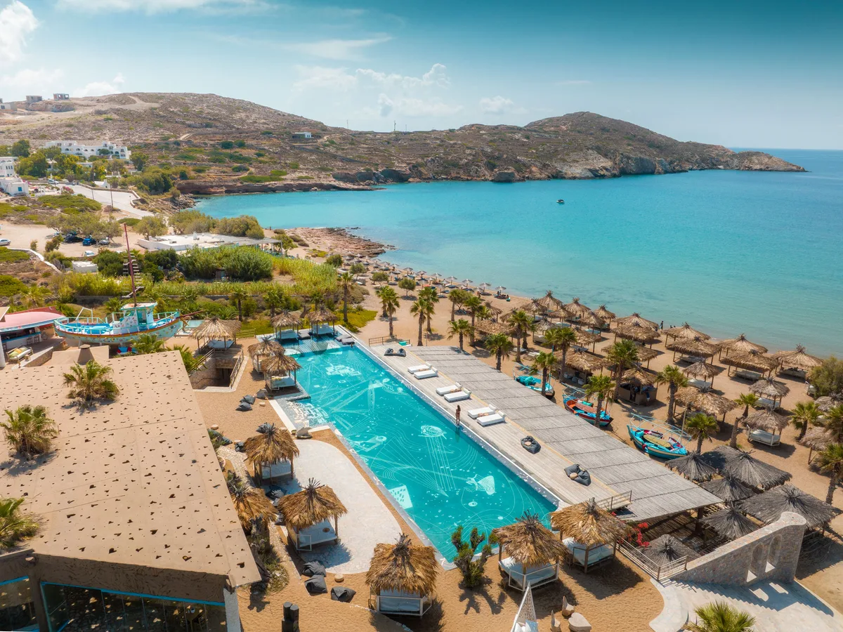 Infinity pool and hanging beach beds under olive trees at Erego Beach Club, Koumbara Beach