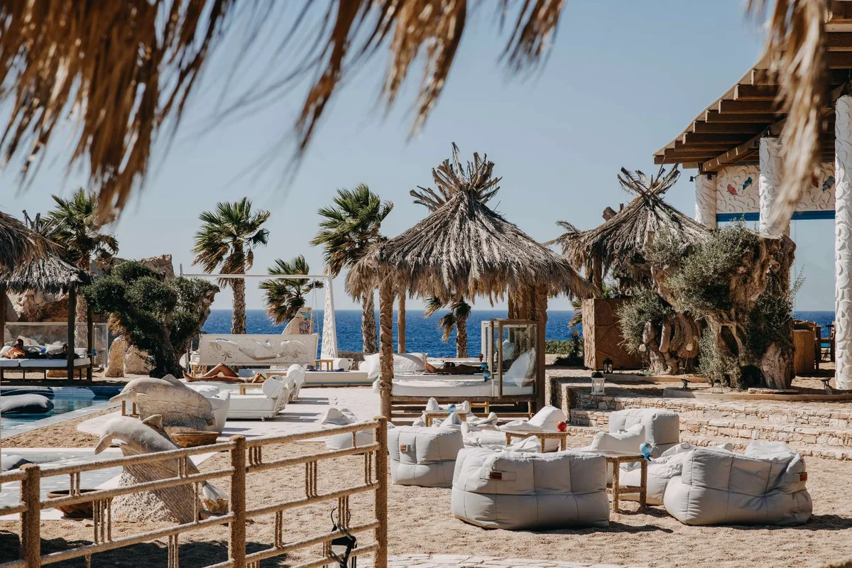 Pool party and sunbeds under palm trees at FarOut Beach Club, Mylopotas Beach