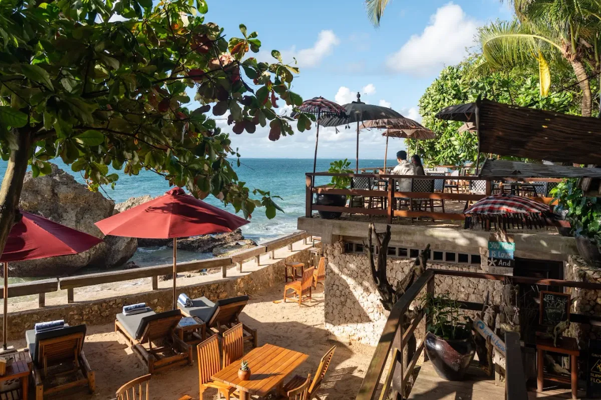 Ocean-facing cabanas on a quiet white-sand cove at Kubu Beach Club, AYANA