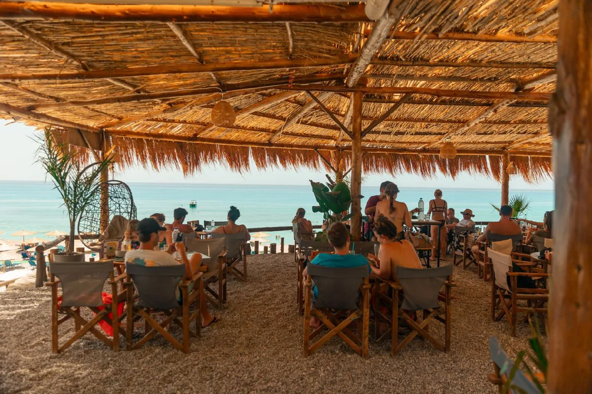 Straw umbrellas and sunbeds on the sand at Medusa Beach Bar, Gialos Beach