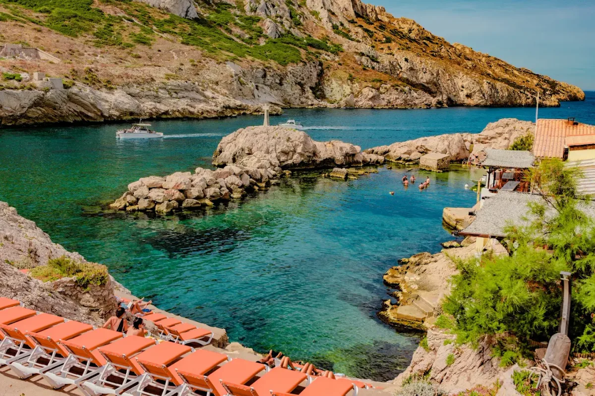 Grilled fish and transats on the white rocks at La Baie des Singes, Cap Croisette