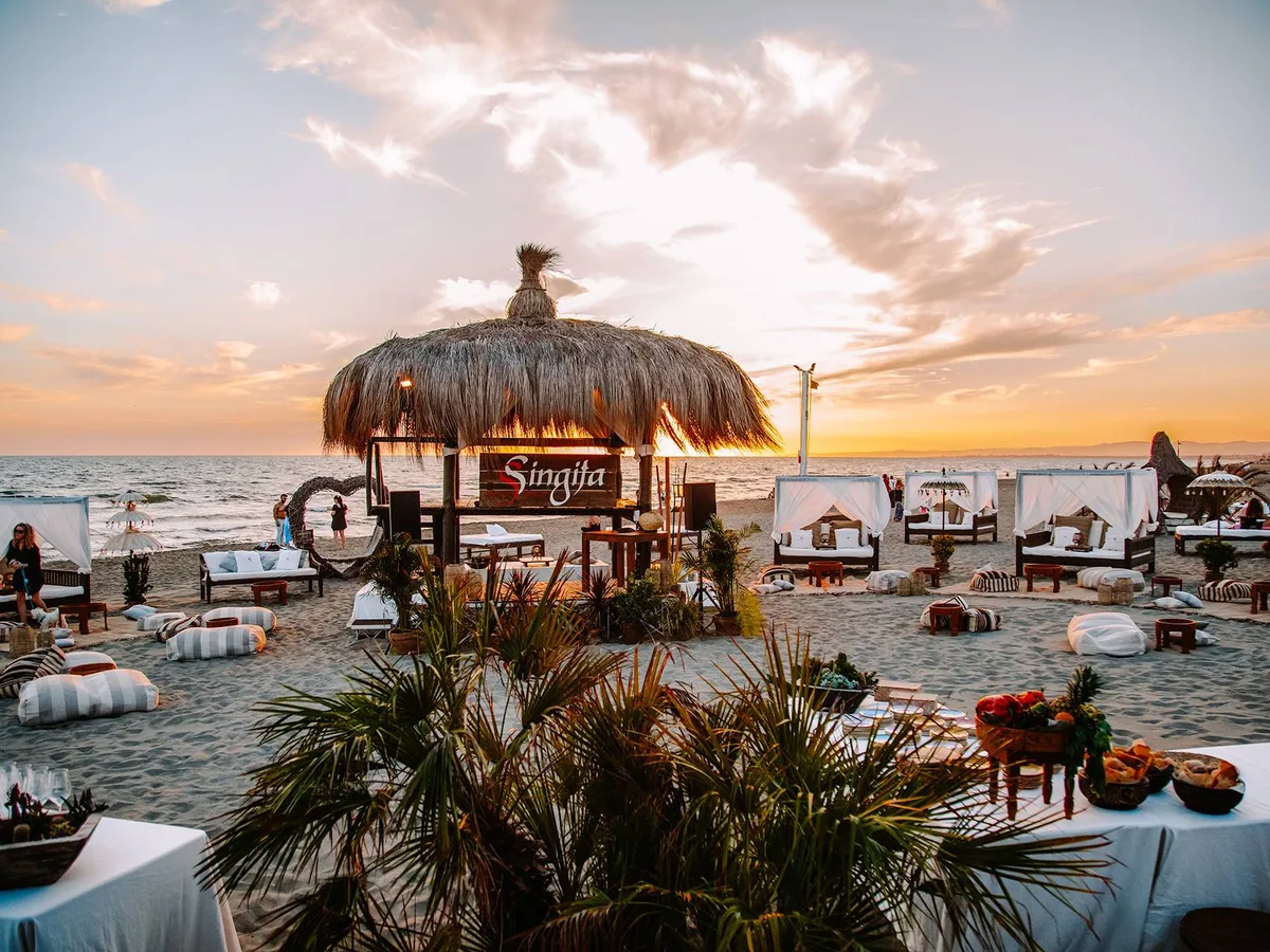 White canopied daybeds at sunset at Singita Miracle Beach, Fregene