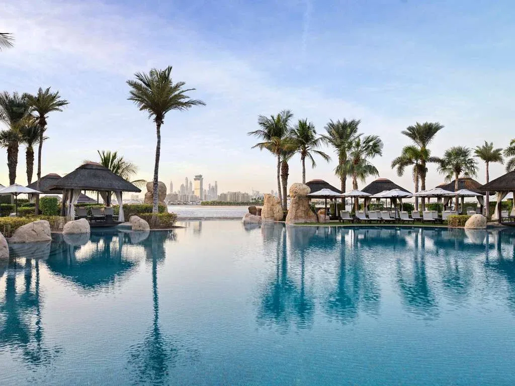Palm-lined pool and beach at Sofitel Dubai The Palm, East Crescent
