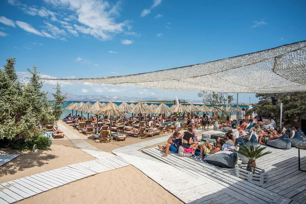 Rows of sunbeds and windsurf sails at Santa Maria Beach Club, northeast Paros near Naoussa
