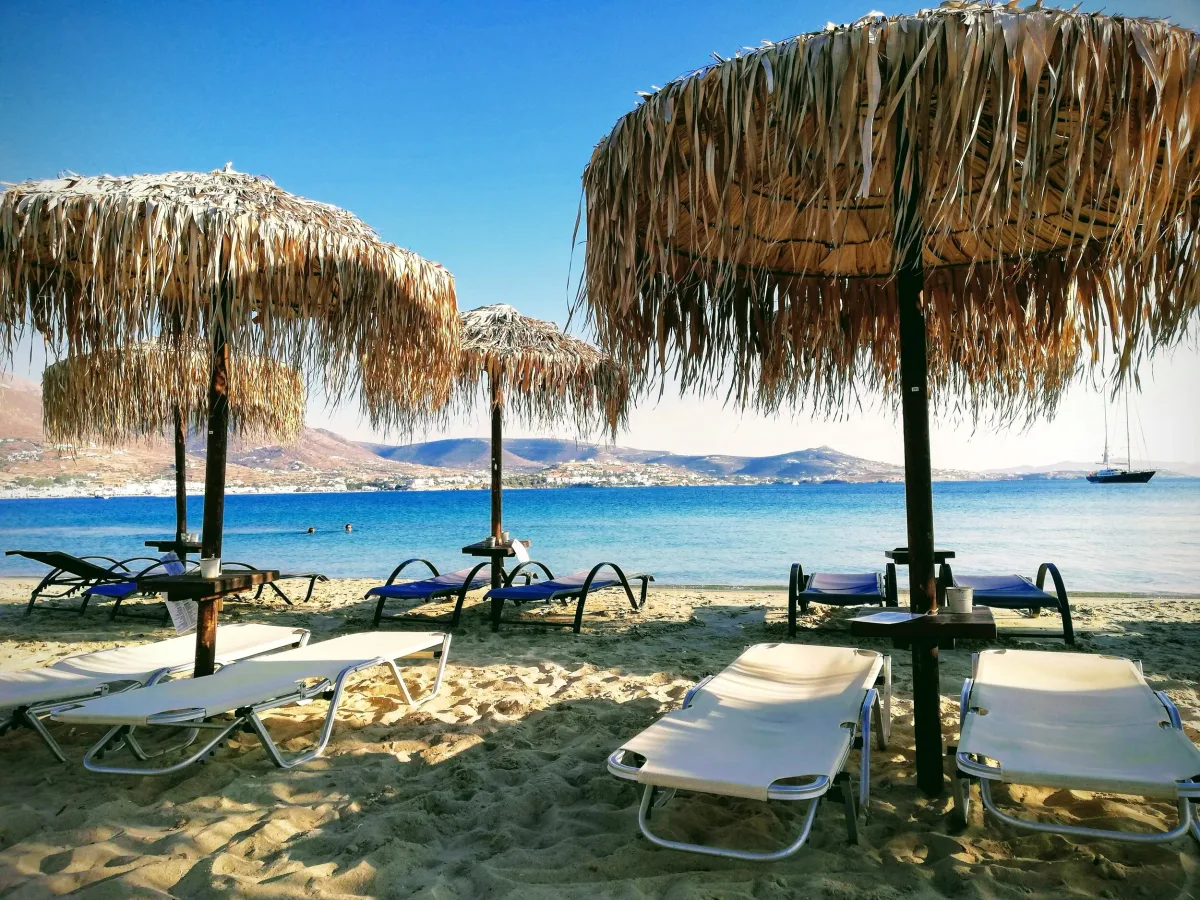 Umbrellas beside calm water at Marcello Beach Bar, Parikia Bay