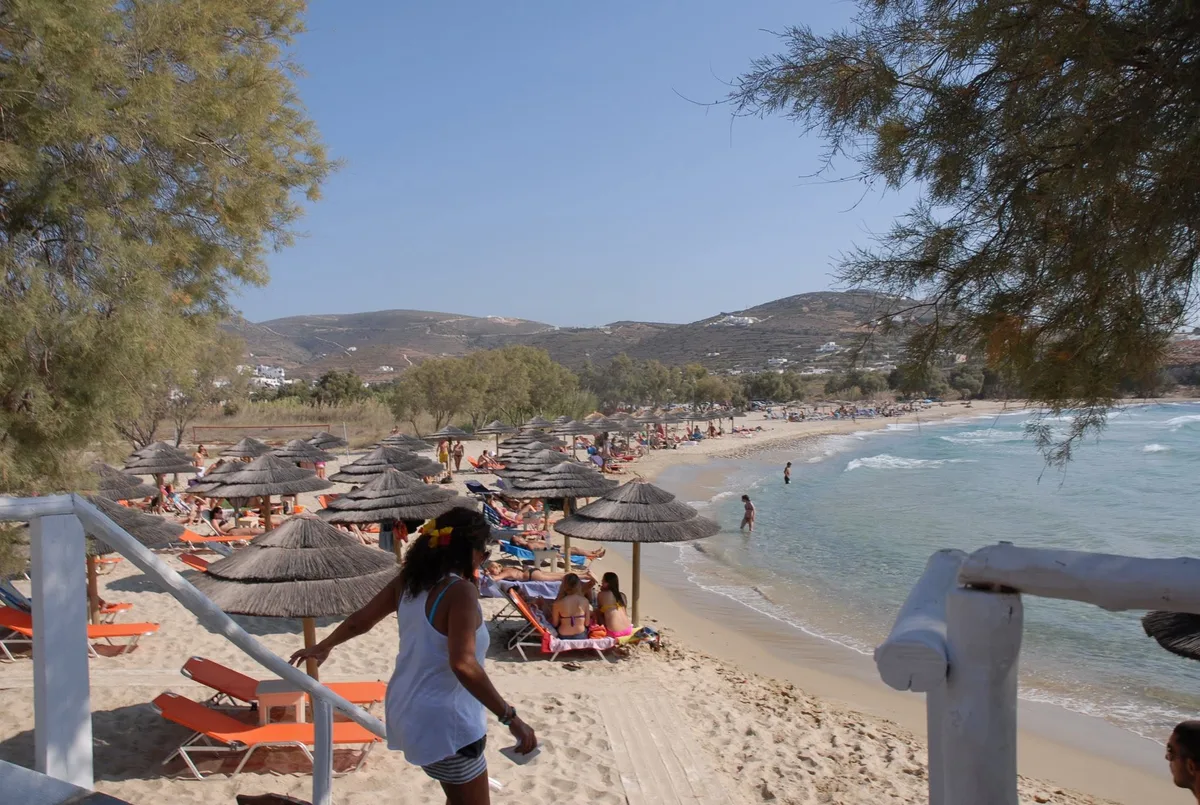 Wide sandy bay and sunset loungers at Parasporos Beach Club, near Parikia