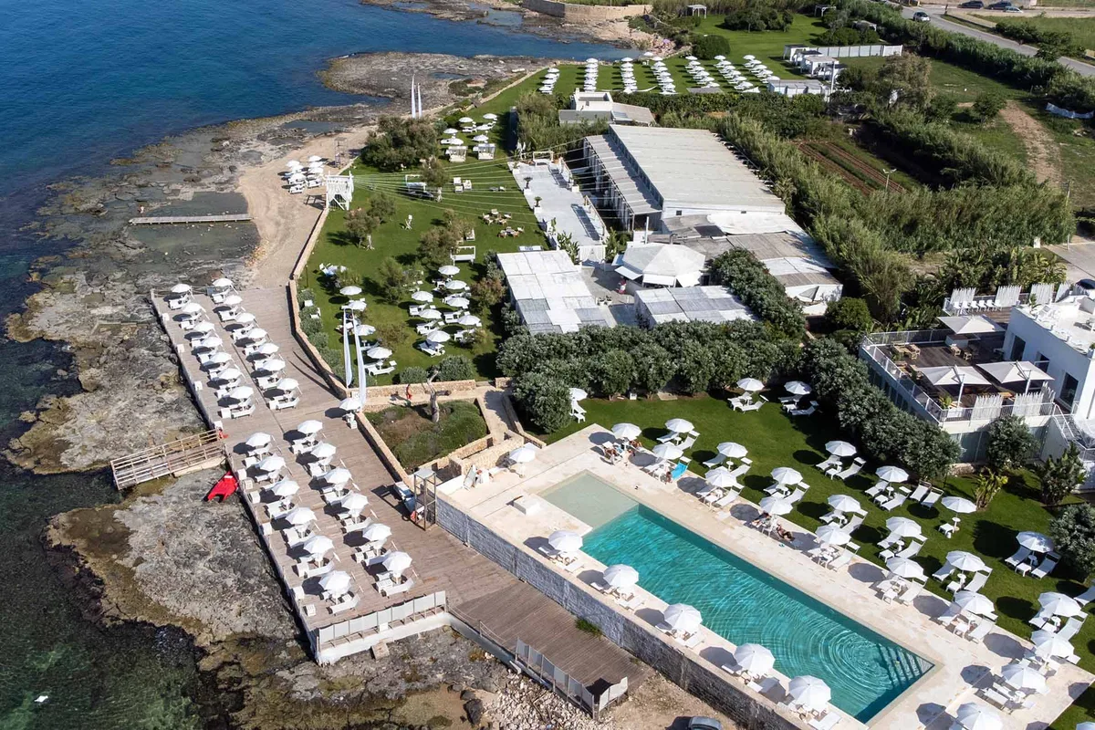 Panoramic pool with white gazebos and linen drapes at Wonder Beach Club, Mola di Bari