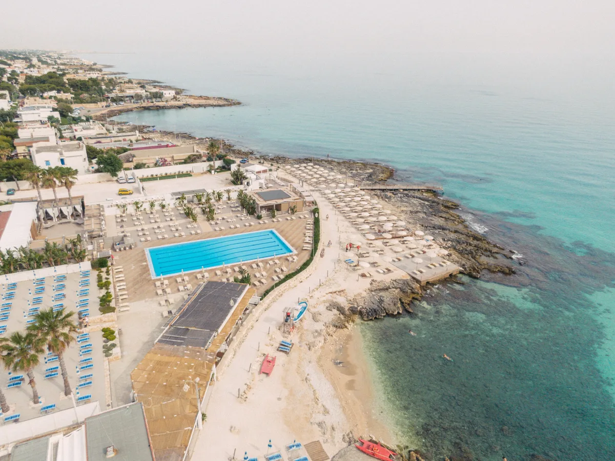 Poolside sunbeds and wooden sea decks at Coco Beach Club, Cozze