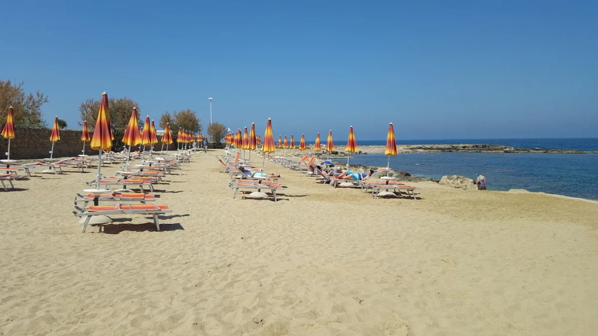Sandy beach with loungers and a beach kitchen at Cala Fetente, San Giovanni area
