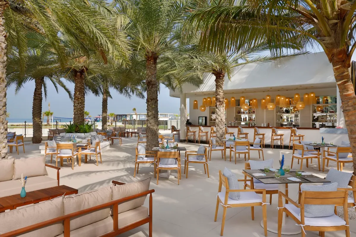 Adults-only infinity pool and private beach cabanas at Sunset Beach Lounge, Al Hamra