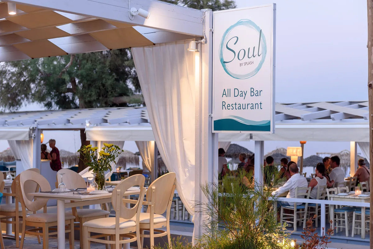 Bean bags and swing chairs on the black sand at Soul by Splash, Kamari Beach