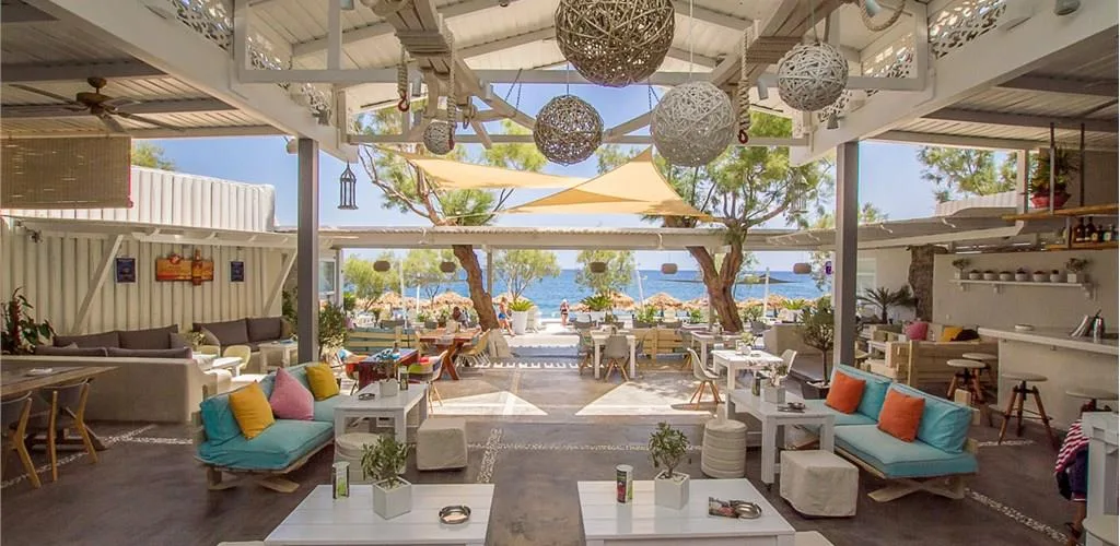 Wooden beach beds under shade canopies at Chilli Beach Bar, Perivolos Beach