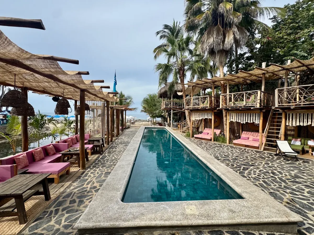 Poolside loungers and beach tables at Trópikos Beach Club, Playa Amor