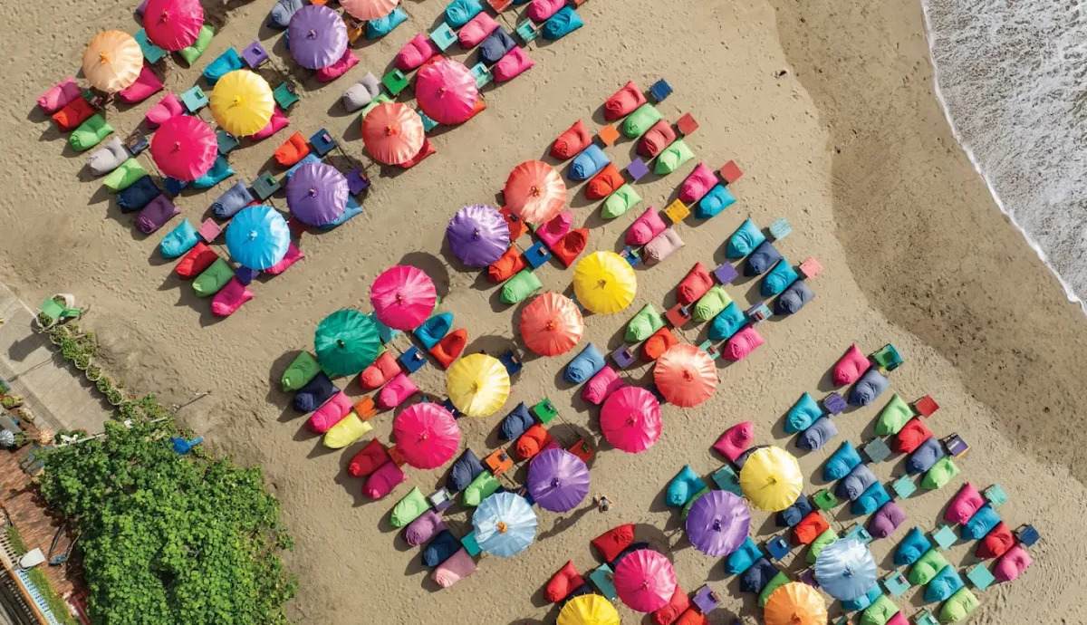 Colourful beanbags lined across the sand at La Plancha Bali, Double Six Beach
