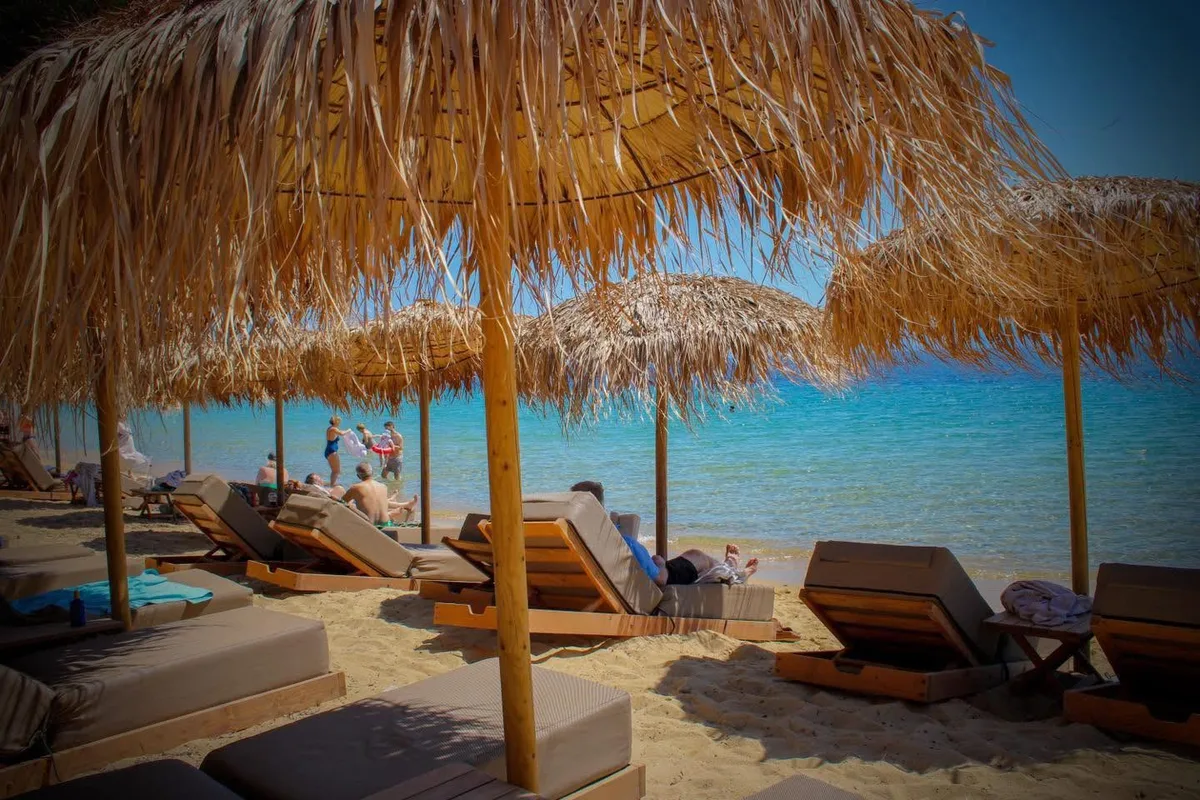 Loungers and watersports on the sand at Porto Paradiso, Vromolimnos Beach