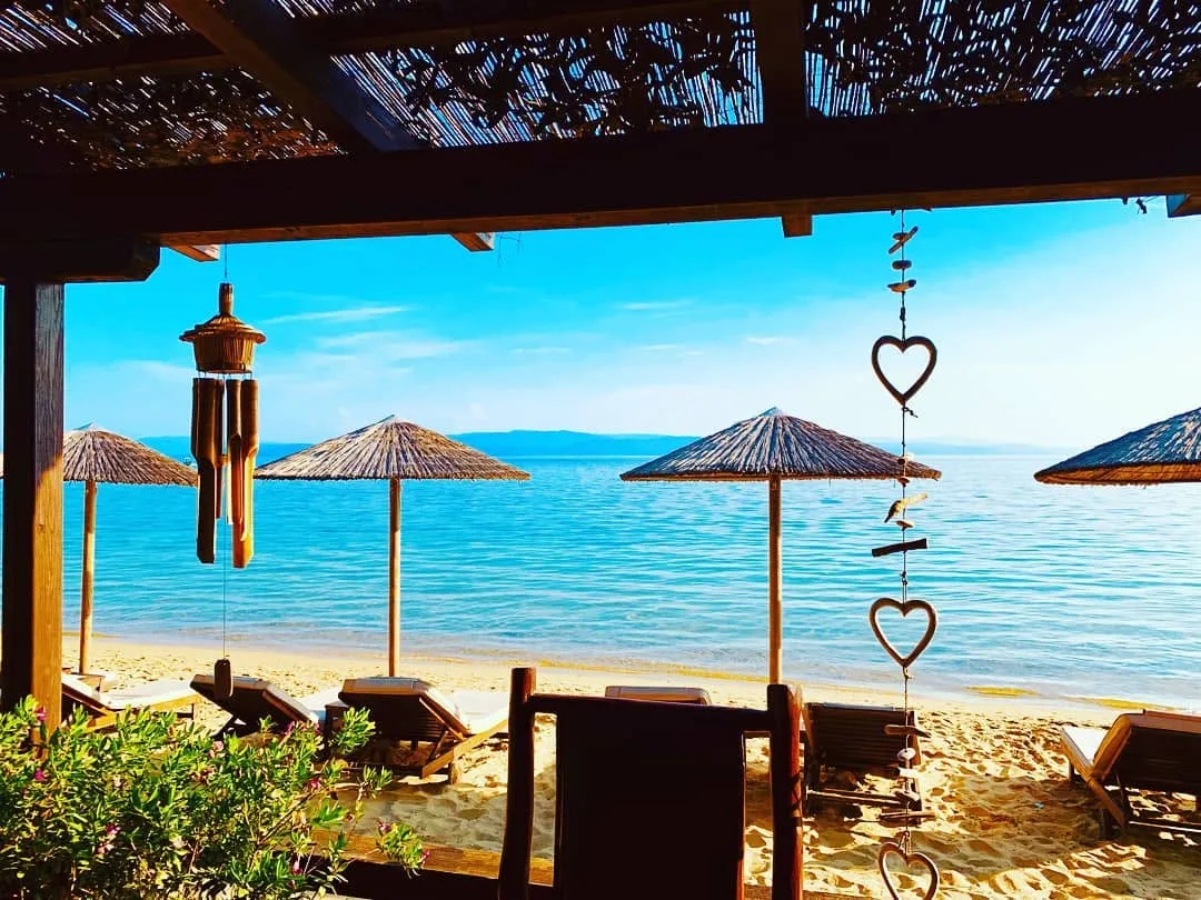 Sun loungers and towel service on a quiet cove at Maratha Beach Bar, Koukounaries