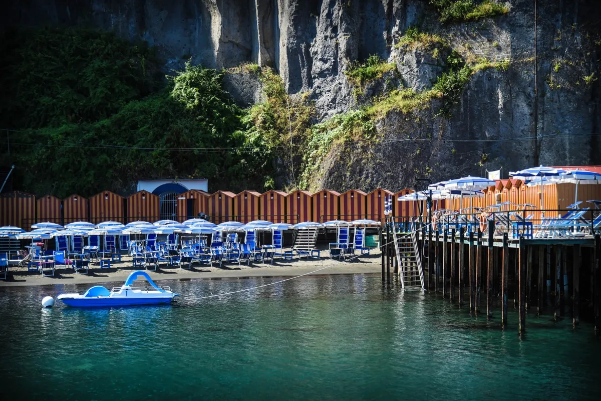 Dark blue and white umbrellas across three terraces at Leonelli's Beach, Marina Piccola