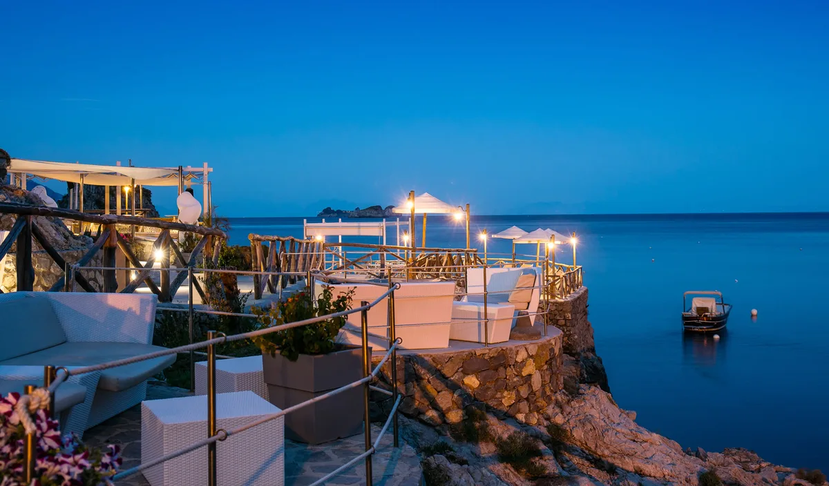 Terrace tables over clear water at La Conca del Sogno, Recommone Bay