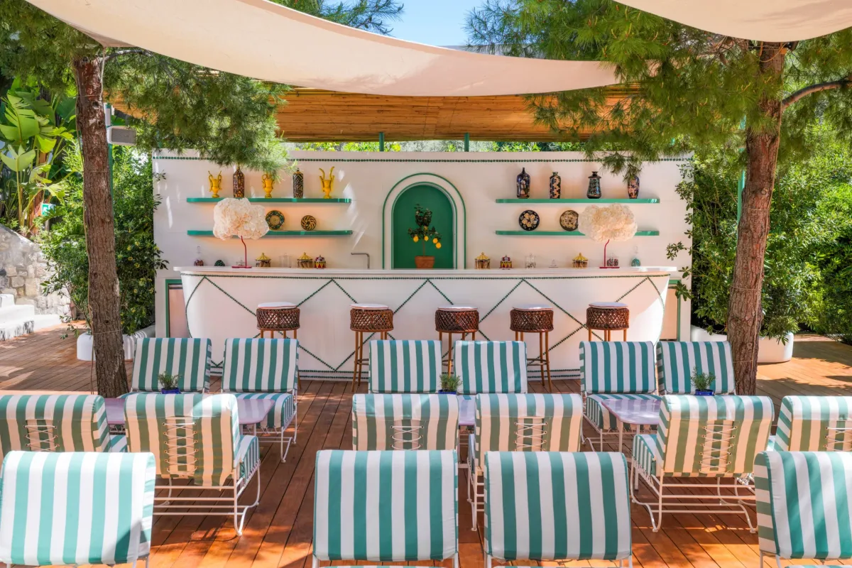 Terraced sunbeds and two jetties above a pebble beach at Le Sirenuse Mare, Nerano
