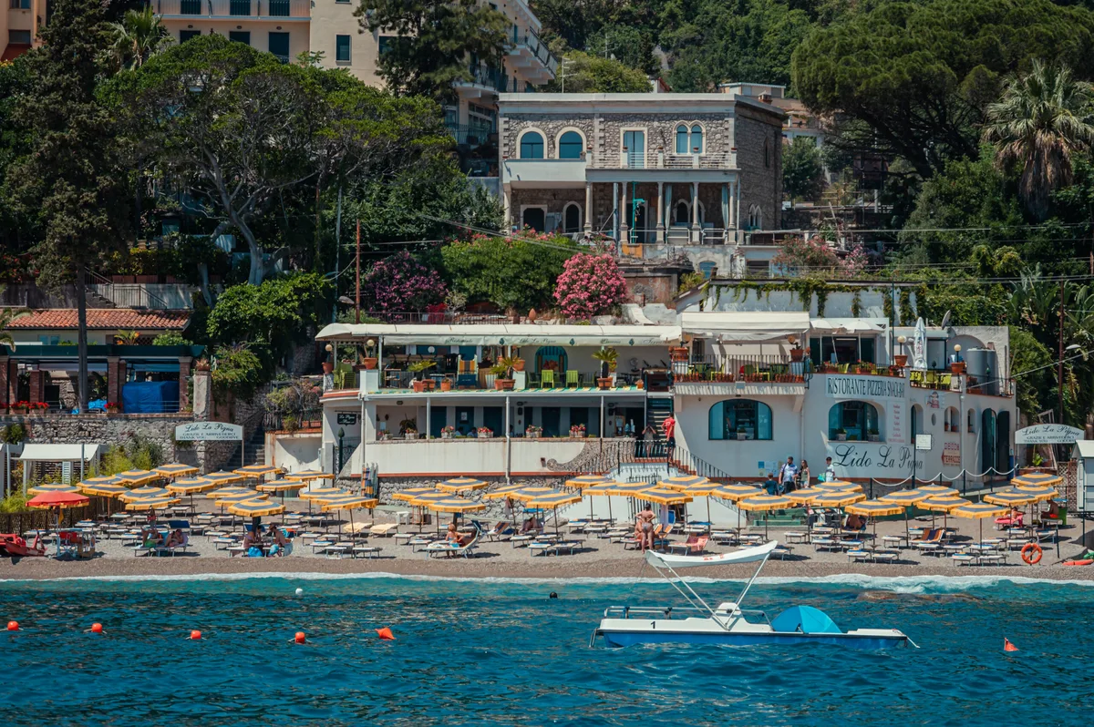 Sunbeds and umbrellas on the pebbles at Lido La Pigna, Mazzarò Bay